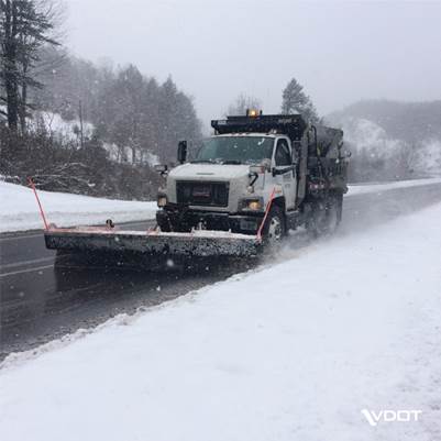 Snowplow moving snow along a road.