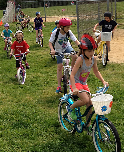 Antietam Elementary School students ride their bicycles across the school’s fields.